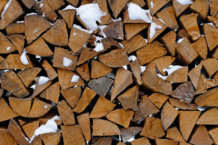 Background of cut wooden logs in the snowの写真素材