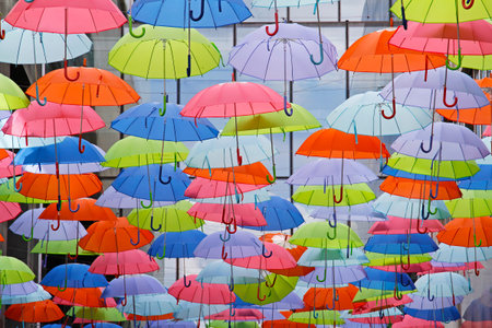 Bright colorful umbrellas as street decoration hanging up in the open air