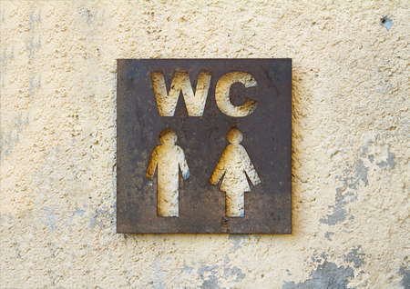 Restroom sign on stone wall background closeupの写真素材