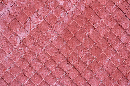 Old red concrete wall with steel mesh as a background or textureの写真素材
