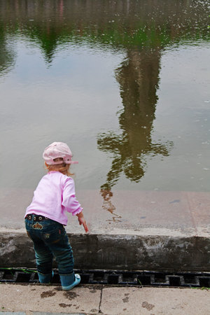 Volgograd, Russia - May 9, 2010: Little girl on the background of reflection of monument "Motherland" in the lake of tears on the Mamaev Kurgan in Volgogradのeditorial素材
