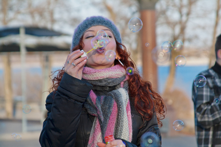 Volgograd, Russia - April 01, 2011: Portrait of young woman blowing soap bubbles on a flashmob in Volgogradのeditorial素材