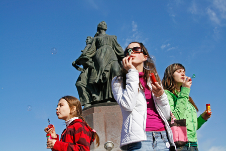 Volgograd, Russia - April 01, 2009: Portrait of young women blowing soap bubbles on the background of the fountain on a flashmob in Volgogradのeditorial素材