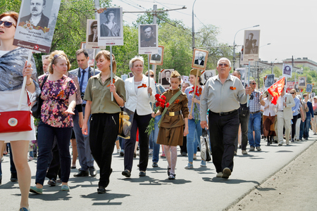Volgograd, Russia - May 09, 2016: Participants of Immortal Regiment with portraits of their relatives walking along the street on Victory day in Volgogradのeditorial素材