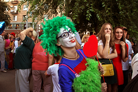 Volgograd, Russia - August 26, 2014: Female clown in green wig and with heart on a stick in the parade of circus performersのeditorial素材
