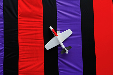 Plane toy made from foam on bright striped backgroundの写真素材