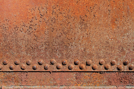 Rusty iron wall with rivets as background or texture