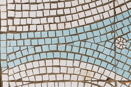 White and blue mosaic tiles with picture of sun or flower on the wall as background or texture
