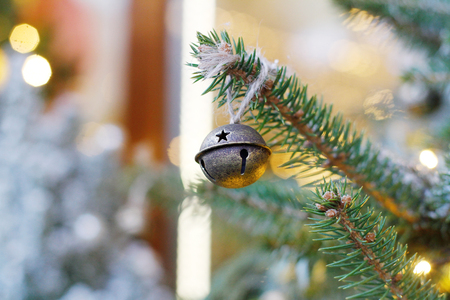 Christmas toy bell hanging on Christmas tree outdoorsの写真素材