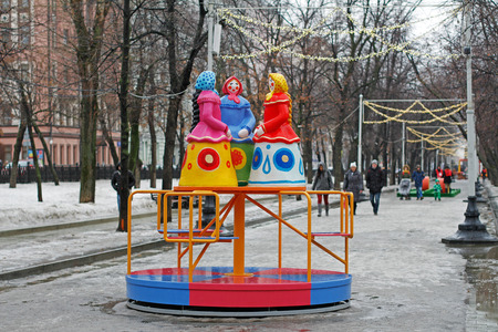 Moscow, Russia - February 21, 2017: Traditional Dymkovo toy three women in headscarves as art object and Children's carousel at Russian national festivalのeditorial素材