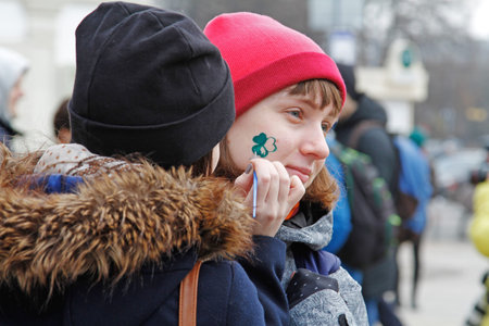 Moscow, Russia - March 18, 2017: Artist draws a Shamrock on girl's face at the St. Patrick's Day Parade in the park Sokolniki in Moscowのeditorial素材