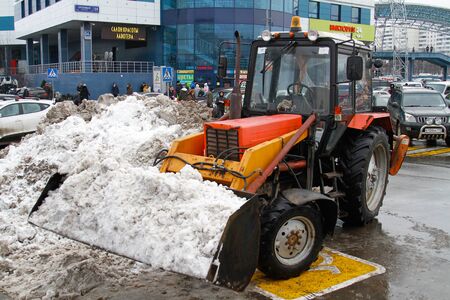 Moscow, Russia - December 27, 2016: A bulldozer with a bucket full of snow standing in the parking near the shopping centerのeditorial素材