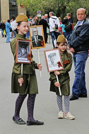 Volgograd, Russia - May 09, 2017: Girls in the military uniform hold portraits of their relatives in the actionのeditorial素材