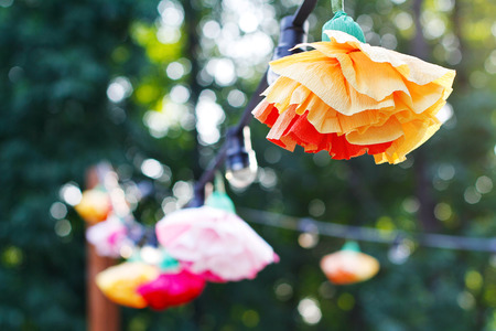 Hanging garland of light bulbs and flowers of corrugated paperの写真素材