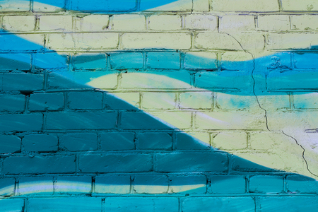 Colorful (yellow and turquoise) painted brick wall as background, textureの写真素材