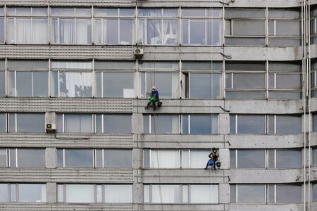 Moscow, Russia - April 30, 2018: Team of climbing workers wash windows of building in Moscowのeditorial素材