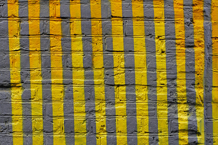 Colorful (yellow and grey) painted striped brick wall as background or textureの写真素材