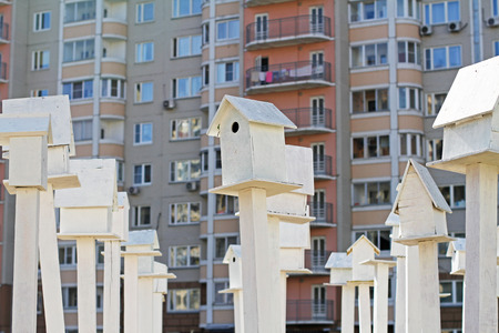 White birdhouses standing in front of an apartment buildingの写真素材