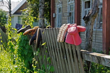 Rubber boots drying on the fenceの写真素材