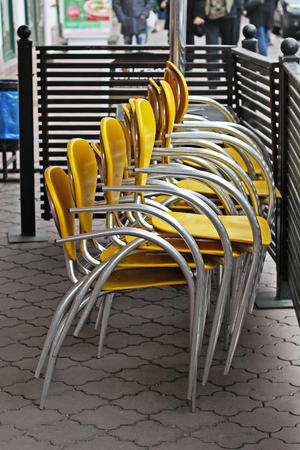 Stacked yellow chairs  on a summer terrace in a cafeの写真素材