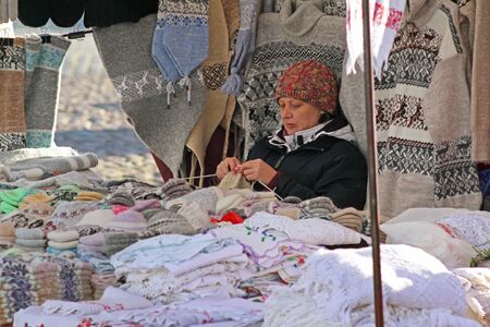 Vyborg, Russia - October 19, 2013: Woman seller sits and knits wool products for sale on the Market Square in the center of Vyborgのeditorial素材