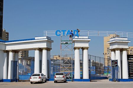 Volgograd, Russia - May 07, 2019: Installers set letters above the entrance to the stadiumのeditorial素材