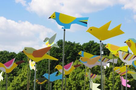 Moscow, Russia - June 15, 2013: Colourful weather vanes in form of birds against trees and a blue sky with clouds at the city festival in Gorky Park in Moscowのeditorial素材