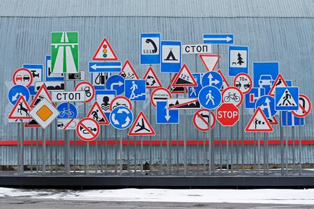 Chaotic set of road signs on a gray wall background (translated from the Russianの写真素材