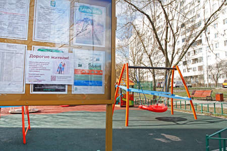 Vidnoe (Moscow region), Russia - April 12, 2020: The announcement about COVID-2019 in Russian hangs on an information board in the background of a closed quarantine playground in the courtyard of Vidnoeのeditorial素材