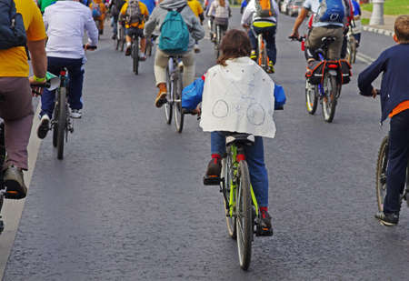 Moscow, Russia - September 22, 2012: A boy in a raincoat with a drawing of a bicycle takes part in bike parade in Moscowのeditorial素材