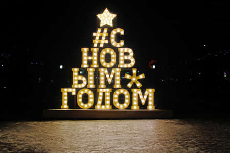 LED installation of a star, a lattice tag and the inscription "Happy New Year" (translated from Russian) stands on the streetの写真素材
