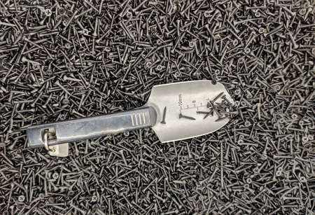 Background or texture of black self-tapping screws on drywall and shovelの写真素材