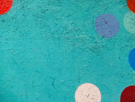 Turquoise painted wall with white, red, blue semicircles and blue circle as background or textureの写真素材