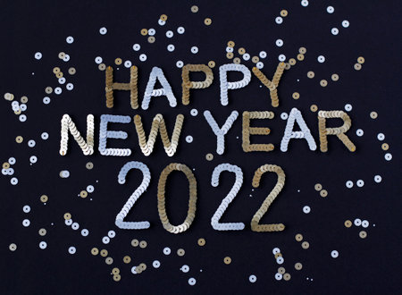 Inscription of Happy New Year 2022 embroidered with silver and golden sequins on black textured...
