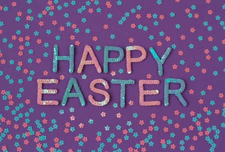 Inscription of Happy Easter embroidered with pink and blue sequins on purple textured background...