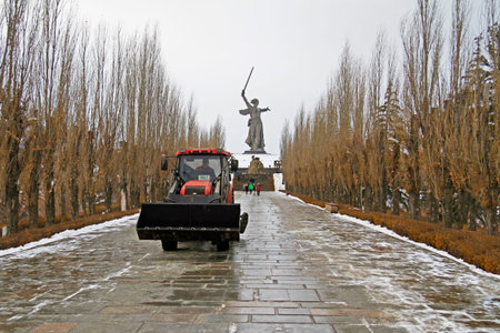 Volgograd, Russia - January 05, 2017: Bulldozer with bucket cleaning the pedestrian road on the...