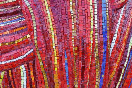 Colorful (red, yellow, orange and blue) stone mosaic tiles on the wall as background or texture
