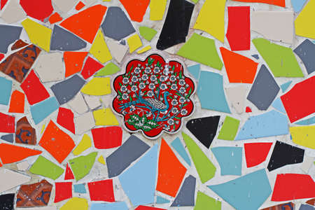 Moscow, Russia - February 12, 2018: Decorative tile with a picture of a bird in a flowering bush surrounded by colorful broken ceramic pieces on facade of building in Moscowのeditorial素材