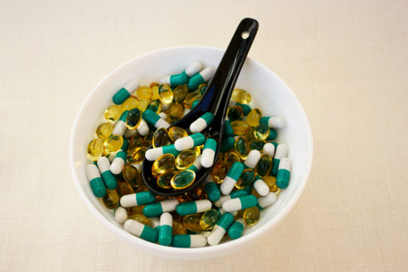 A scattering of different  tablets. Pills in a bowl on a woven background. Advertising a Healthy lifestyle, but also the possibility of  addiction to the medication and excess dosage. Horizontal.の写真素材