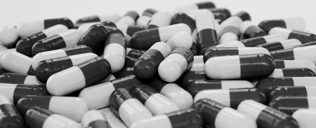 Black and white photo of medical capsules on white background.の写真素材