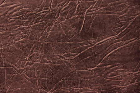 Colored skin texture, natural or faux leather background. Brown leatherette, closeup.