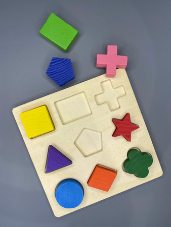 Wooden blocks and figures of different colors on a gray background.