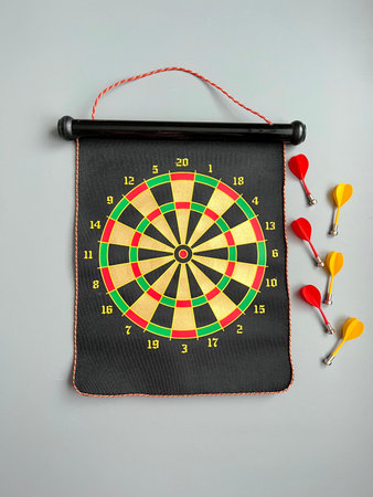 Darts board with dart arrow and dartboard on gray background.
