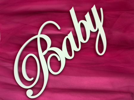 The word baby written in white letters on a pink satin backgroundの写真素材