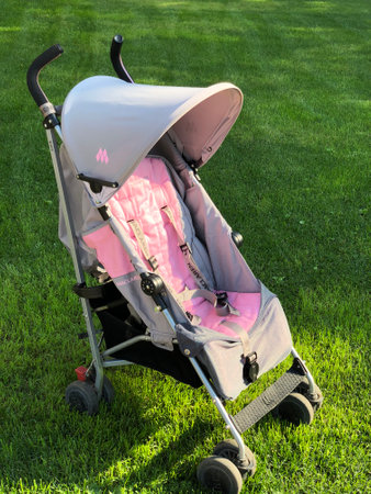 Baby carriage on green grass in the park, closeup of photoの写真素材
