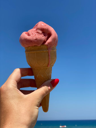 Ice cream in a waffle cone on the background of the sea and blue sky