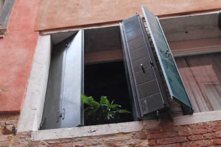 Old window with shutters on the facade of a building in Venice, Italy