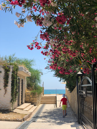 A young boy walks along the walkway to the sea in Cyprus