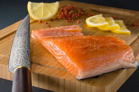 A piece of salted salmon on a cutting Board, prepared for slicingの写真素材