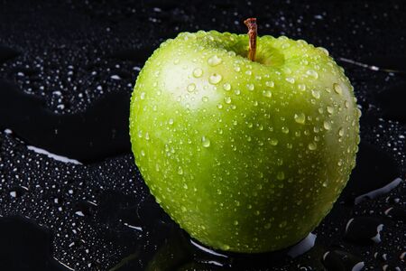 green Apple with yellow autumn leaves and a branch in the waterの写真素材
